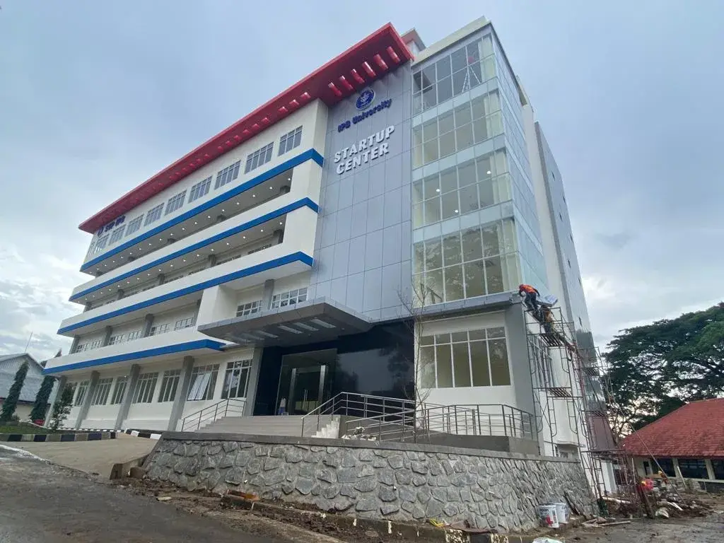 Tampak Gedung IPB Multitenant di Bogor dengan panel pada fasad dan tulisan Startup Center.