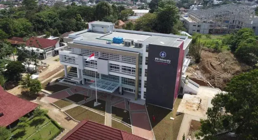 Tampak udara Gedung IPB Vokasi di Bogor dengan bidang panel gelap pada fasad bangunan.