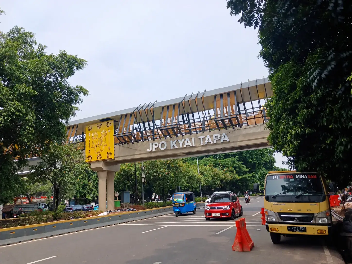 Tampak JPO Kyai Tapa di Jakarta dengan bentang jembatan, elemen dekoratif, dan panel pada bagian atas struktur.