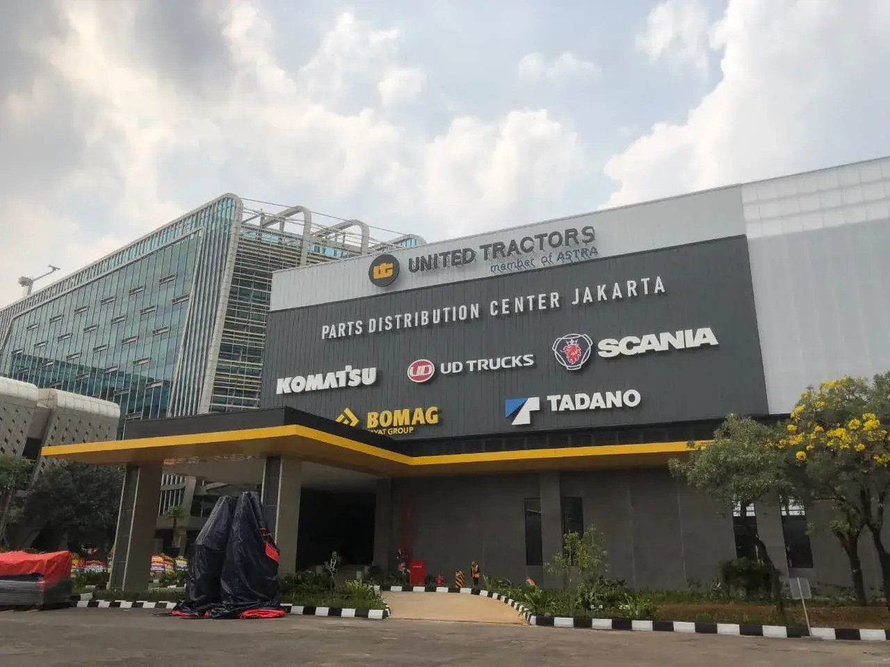 Tampak bangunan UT Smart Warehouse di Jakarta dengan fasad kaca dan area pintu masuk.