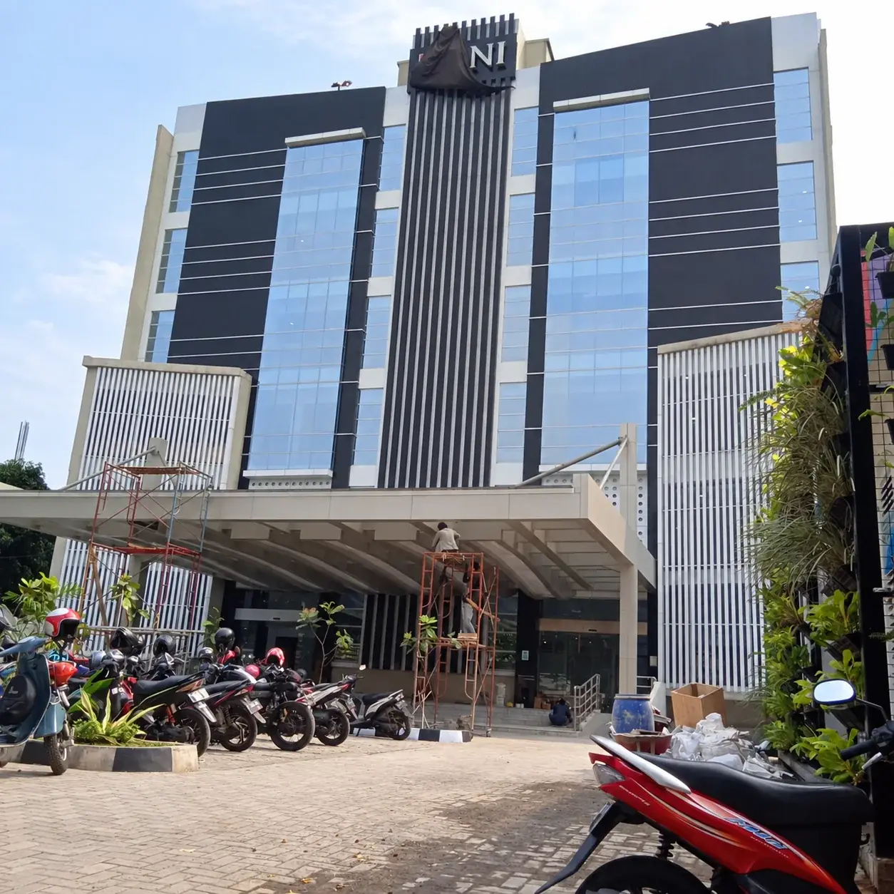Tampak area eksterior BNI Jatinegara di Jakarta dengan elemen kaca dan panel pada bangunan.