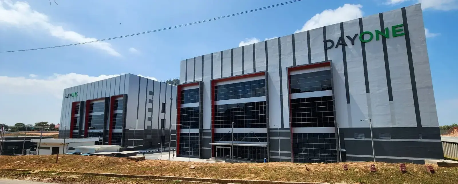 Tampak eksterior Data Center Nongsa di Batam dengan panel Aluminium Composite Panel (ACP) dan bidang fasad kaca.