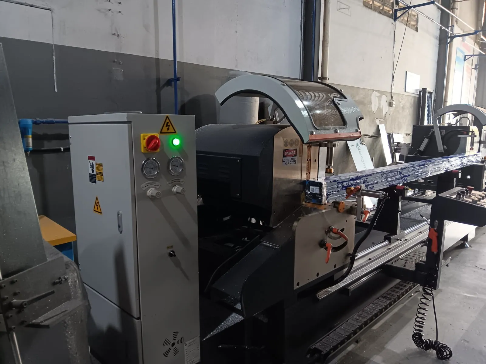 Mesin potong Demac dengan profil aluminium di workshop