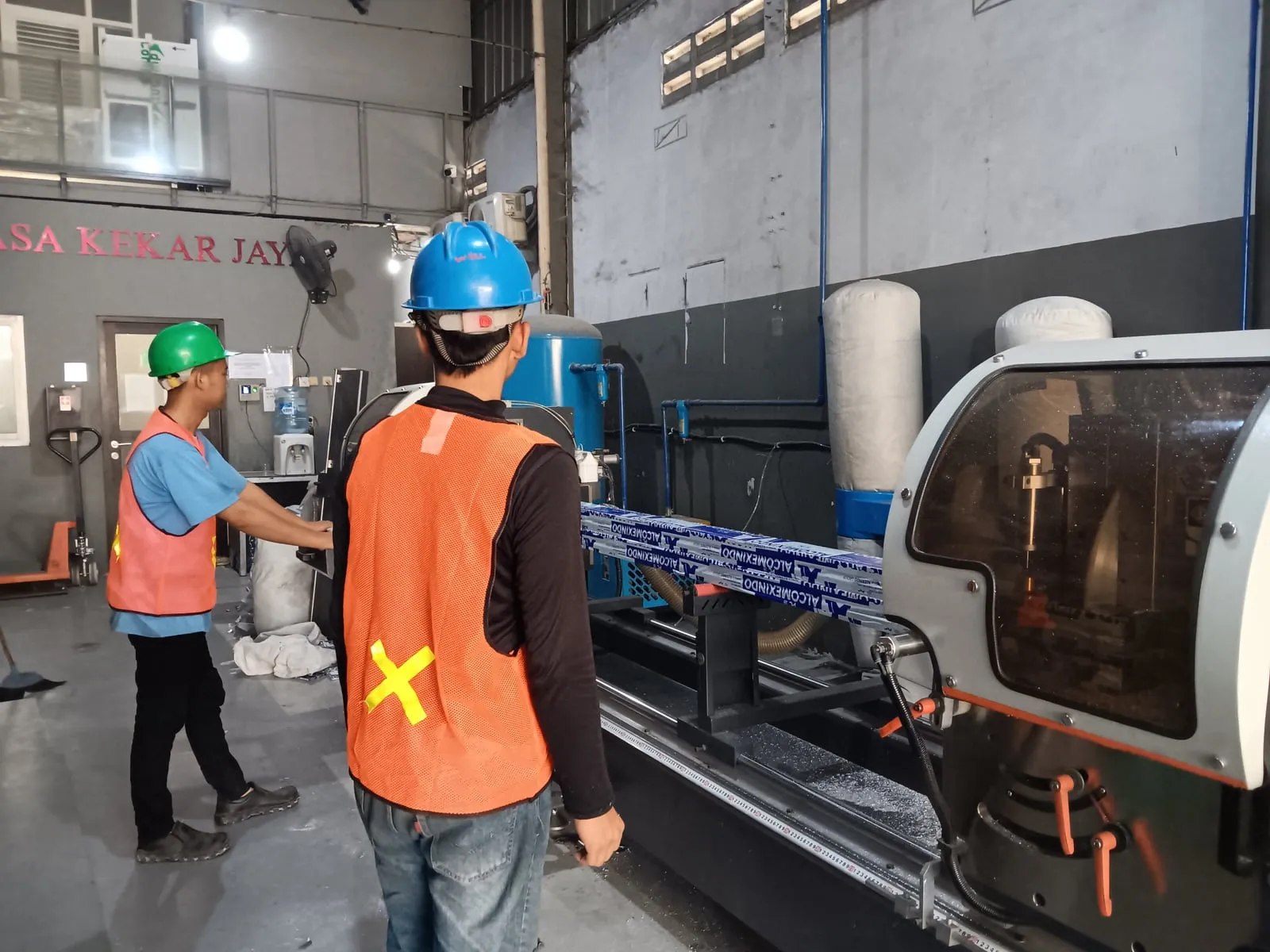 Tim workshop memakai helm keselamatan dan rompi visibilitas tinggi